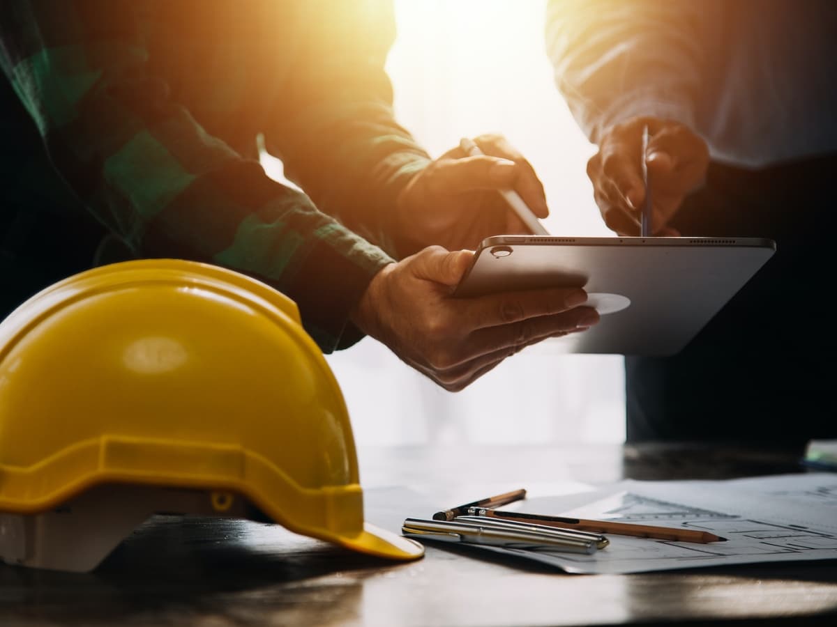 Roofing contractor reviewing QuotePilot leads on a tablet at a job site